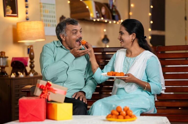 daughter-and-father-eating-sweets-by-sharing-together-at-home-during-diwali-festival-celebration-at-home