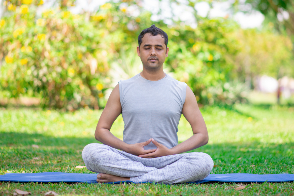 focused-young-indian-man-meditating-lotus-pose